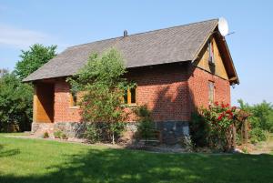 a red brick house with a tree in the yard at Rozītes in Cesvaine