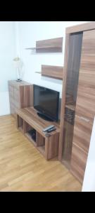 a wooden entertainment center with a flat screen tv at Apartman AMORE Belvil in Novi Beograd