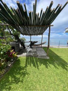una sedia sotto un ombrellone sull'erba vicino alla spiaggia di PK 35 a Apomaoro
