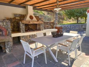 a patio with a table and chairs and an outdoor oven at Casa Calma Villa Greece in Diakopto