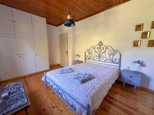 a bedroom with a bed with a blue and white bedspread at Casa Calma Villa Greece in Diakopto +21 photos