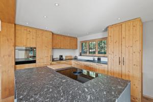 a kitchen with wooden cabinets and a black counter top at A&Y Chalet zum goldenen Hirsch in Davos