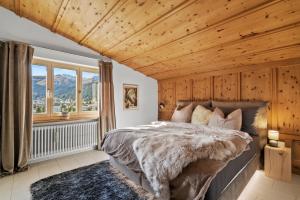 a bedroom with a bed and a wooden ceiling at A&Y Chalet zum goldenen Hirsch in Davos
