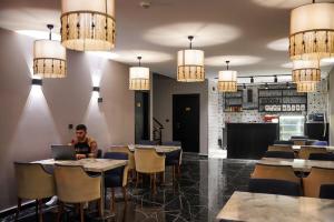 a man sitting at a table with a laptop in a restaurant at KY Continental Apartments in Izmir