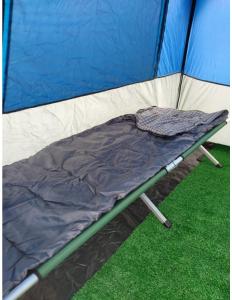 a camping bed in a tent withgrass at Avistamiento de Ballenas y Campamento Todo incluido!! Mínimo 3 noches en Mag Bay in Punta Cove +12 photos