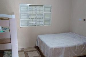 een kleine slaapkamer met een bed en een raam bij Chacara São Pedro in Socorro