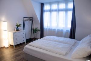 sypialnia z łóżkiem, komodą i oknem w obiekcie BeMyGuest - 3 Zimmer Maisonette - Zentral - Klimaanlage - Aufzug w mieście Wiesbaden