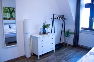 een slaapkamer met een wit dressoir en een bed bij BeMyGuest - 3 Zimmer Maisonette - Zentral - Klimaanlage - Aufzug in Wiesbaden