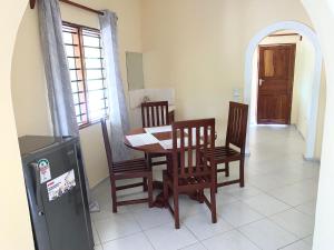 a dining room with a table and four chairs at Delicious House, Watamu 2-bedroom with own compound free parking and wifi in Watamu