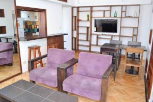 sala de estar con sillas de color púrpura y mesa en Libertador 2785 by depptö in 
