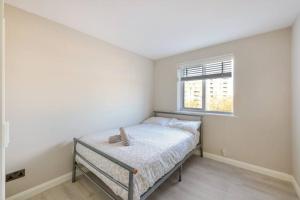 a bedroom with a bed and a window at Luxury Apartment in Kingston in Kingston upon Thames