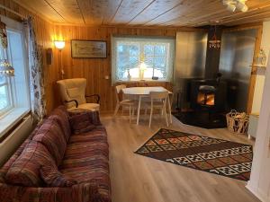 - un salon avec un canapé et une table dans l'établissement Stuga Bergvik, à Gällö