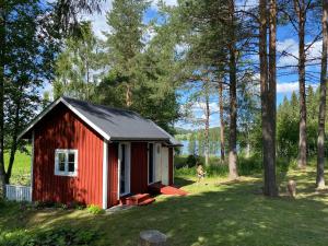 un cobertizo rojo en medio de un patio en Stuga Bergvik, en Gällö