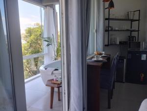 a bathroom with a tub and a table and a window at North Suíte in Florianópolis