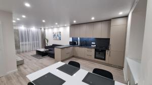 una cucina e un soggiorno con tavolo e divano di New apartment in the city a Šiauliai