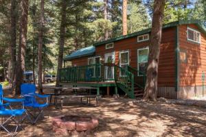 a cabin in the woods with a picnic table and chairs at The Blue Devil Cabin #5 at Blue Spruce RV Park & Cabins in Tuckerville