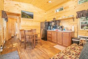 a kitchen with a table and chairs in a cabin at The Blue Devil Cabin #5 at Blue Spruce RV Park & Cabins in Tuckerville +19 photos