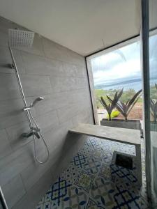 uma casa de banho com um chuveiro e uma porta de vidro em Casa campestre Lago Calima em Calima