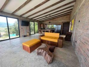 um quarto grande com dois bancos, uma mesa e janelas em Casa campestre Lago Calima em Calima