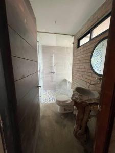uma casa de banho com um WC, um lavatório e uma janela em Casa campestre Lago Calima em Calima