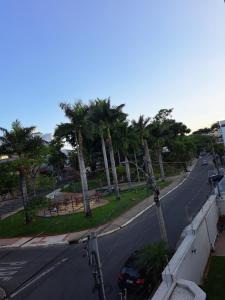 an empty street with palm trees and a car on the road at Portal do Jaragua in Belo Horizonte