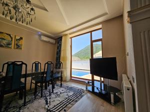- une salle à manger avec une table et une vue sur l'océan dans l'établissement Qafqaz Panoramic Mountain Chalet, à Qabala