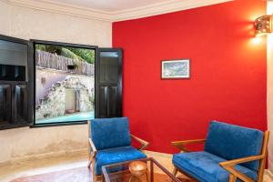 2 sillas en una habitación con una pared roja en Casa Clorinda, en Campeche