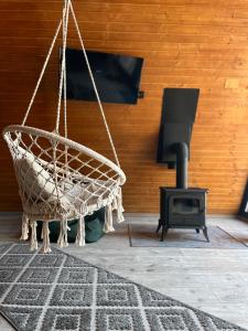 a hammock and a stove in a living room at Rock Valley Cabins in Ibăneşti