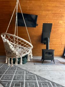 a hammock and a stove in a living room at Rock Valley Cabins A-frame in Ibăneşti