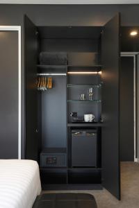 a bedroom with a black wall with shelves and a bed at Travelodge Hotel Auckland Wynyard Quarter in Auckland