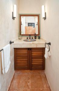 y baño con lavabo y espejo. en Casa Clorinda, en Campeche