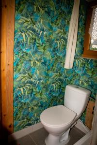 um WC numa casa de banho com papel de parede azul e verde em Domek w ogrodzie niedaleko Krakowa em Paszkówka