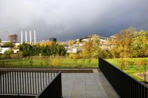 a balcony with a fence and a city in the background at Beautiful 2BR Apartment in Kirchberg in Luxembourg