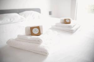 1 cama con toallas y reloj despertador. en Beautiful 2BR Apartment in Kirchberg, en Luxemburgo