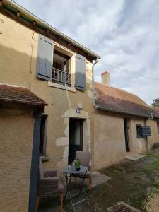 a small table in front of a building with a window at LE BLANC, AGREABLE MAISON DE CENTRE VILLE in Le Blanc