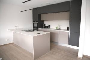 a kitchen with white counters and black cabinets at Beautiful 2BR Apartment in Kirchberg in Luxembourg