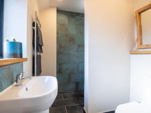 a bathroom with a white sink and a stone wall at Appletree Barn in Lower Soudley
