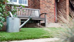 a trash can next to a bench in a yard at St. Peter's Close in London