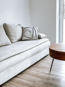 DoreyHome I Luxus - Stylish - Modern House I Parking I Smart TV I Netflix WLAN في باساو: أريكة في غرفة معيشة مع طاولة خشبية