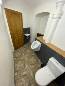 a bathroom with a toilet and a sink and a mirror at Apartmány u náměstí in Prachatice