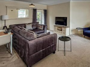 a living room with a brown couch and a television at Cottage 2 - Uk45645 in Lowick