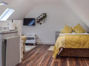 a bedroom with a bed and a tv on a wall at The Loft At Tall Trees in Welton
