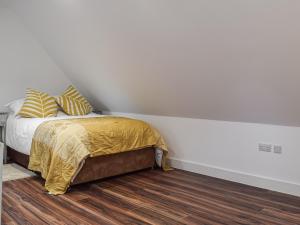 a bedroom with a bed with yellow blankets and pillows at The Loft At Tall Trees in Welton