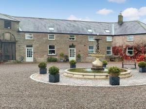 a courtyard with a fountain in front of a building at Cottage 2 - Uk45645 in Lowick
