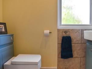 a bathroom with a toilet and a window at Garden Studio in St Austell