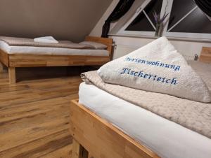 2 łóżka w pokoju z drewnianą podłogą w obiekcie Ferienwohnung Fischerteich in Detmold w mieście Detmold