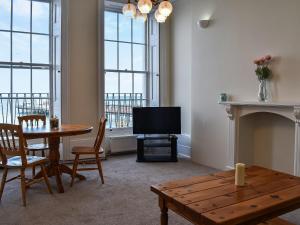 a living room with a table and a television at Coastal Charm in Herne Bay