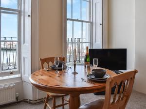 a dining room with a wooden table with a bottle of wine at Coastal Charm in Herne Bay