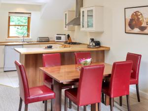a kitchen with a wooden table and red chairs at Family Lodge No, 4 - Uk45693 in Moulin