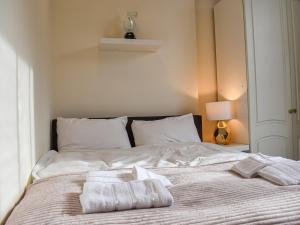 a white bed with two towels on top of it at Coastal Charm in Herne Bay